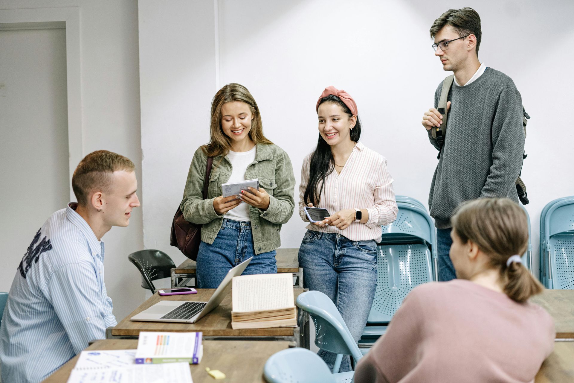 College students hanging out together around desks.