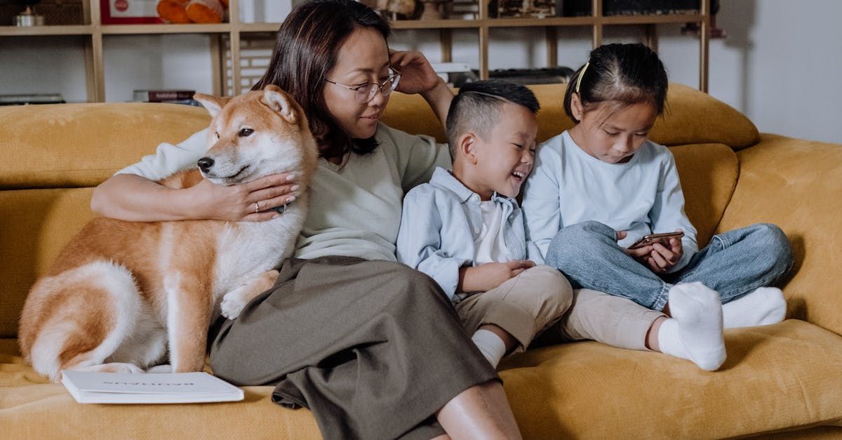 A mom with her kids and dog on the couch.