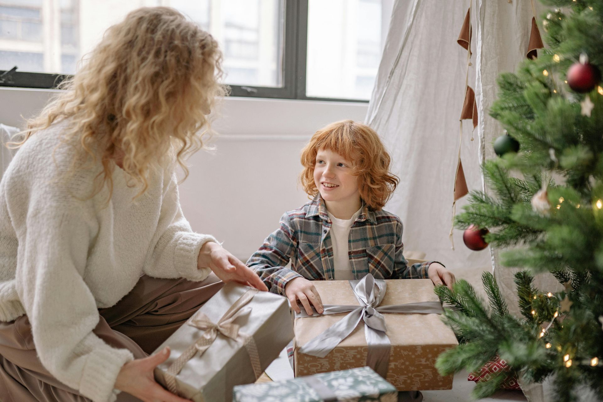 A mom and her son wrapping gifts.