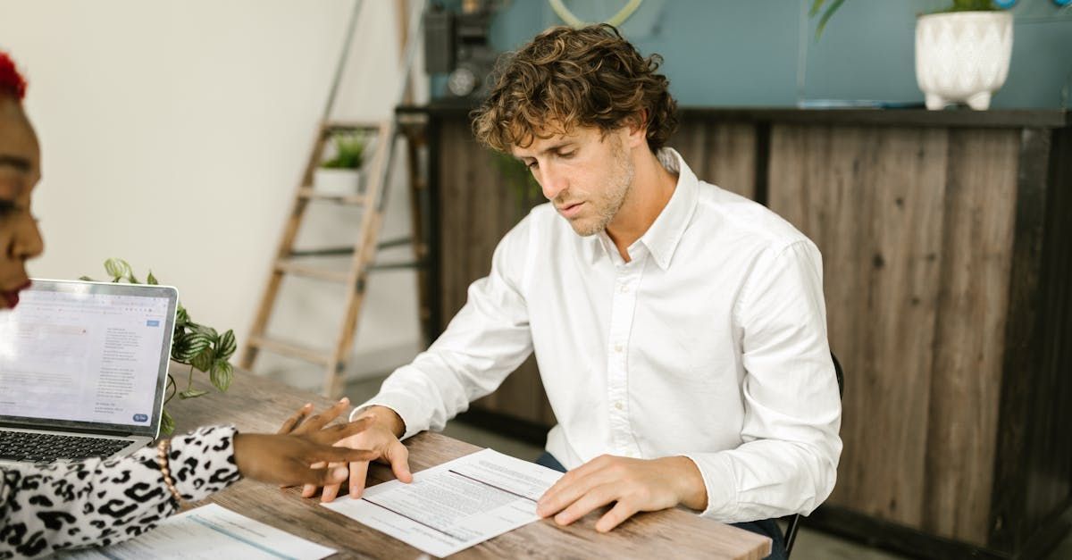 Two people sat at a desk discussing a piece of paper.