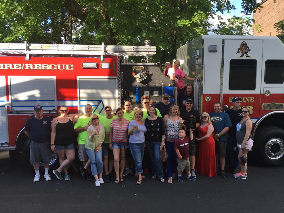 A group of people posing in front of a fire rescue truck