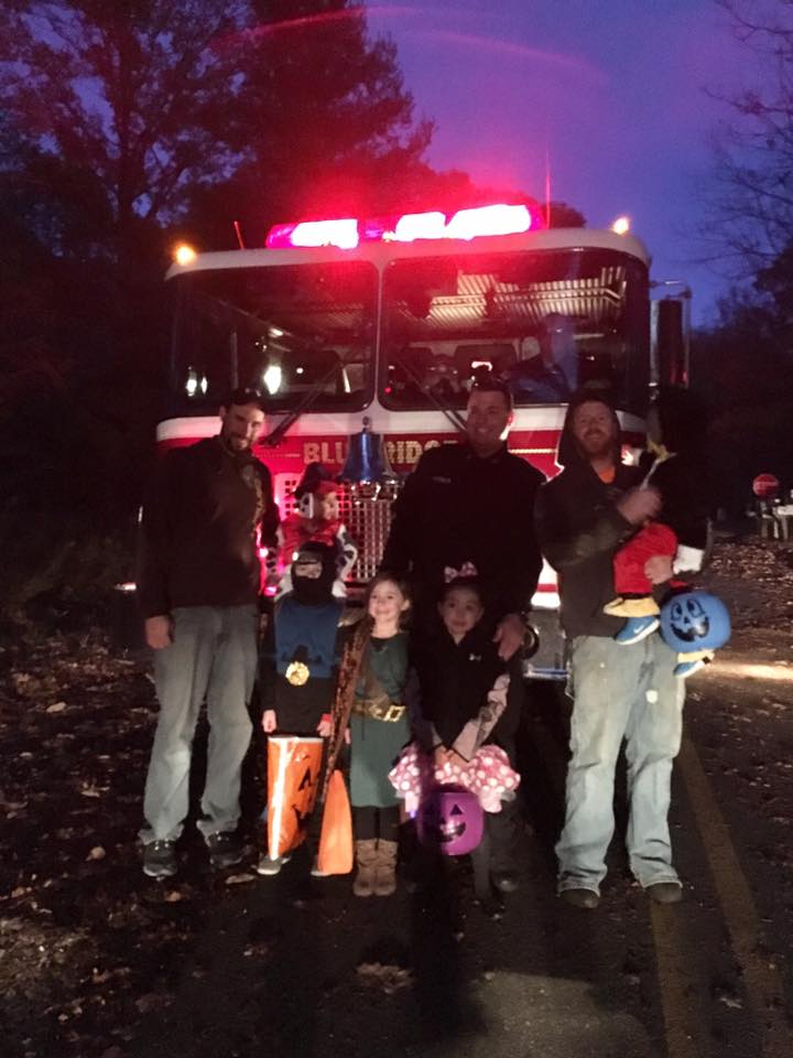 A group of people standing in front of a blt fire truck