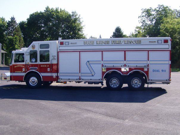 A red and white fire truck is parked in a parking lot