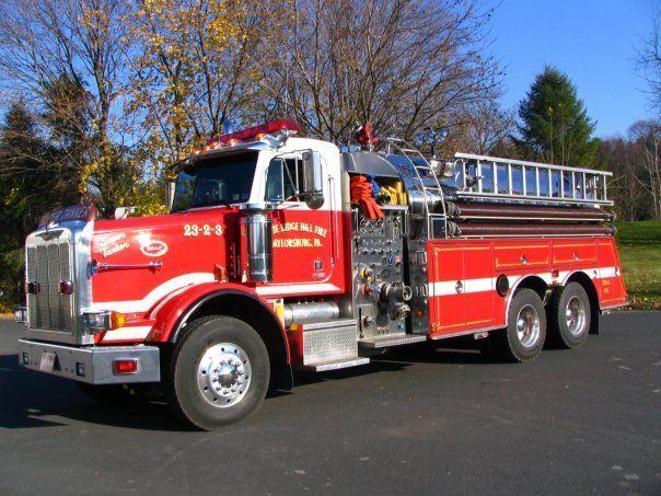 A red and white fire truck is parked on the side of the road