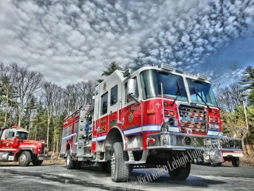 A red and white fire truck is parked in a parking lot.