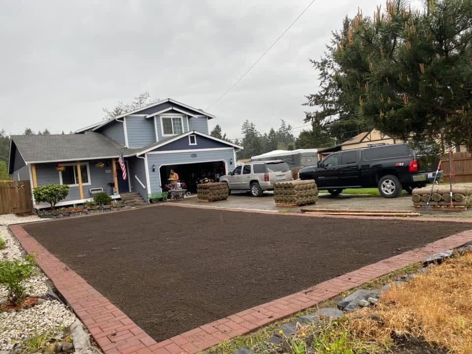 A blue house with a black truck parked in front of it.