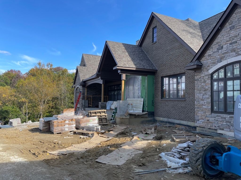 A large brick house is being built on top of a dirt hill.