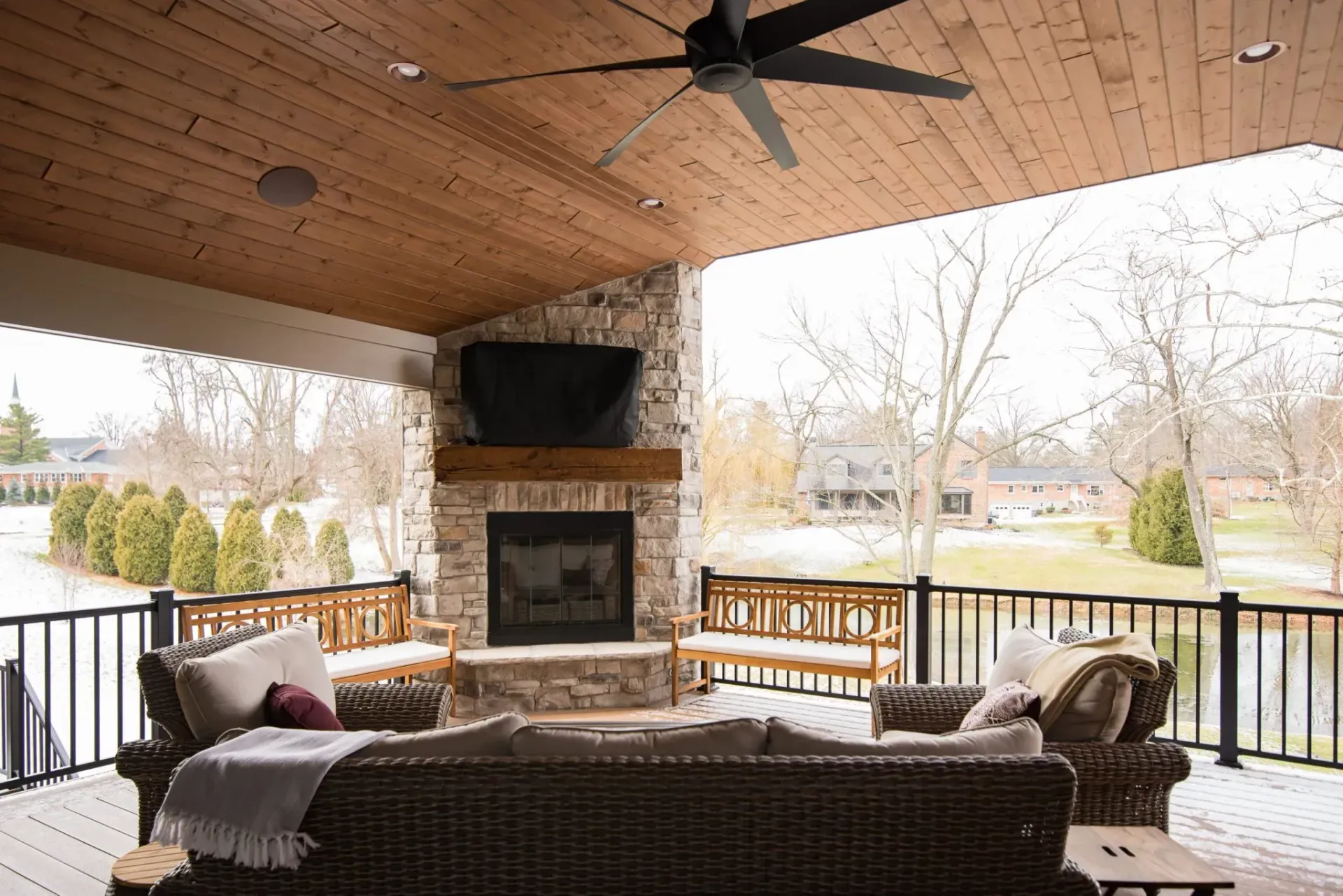 A patio with a fireplace and a ceiling fan Installed by Reston Construction.