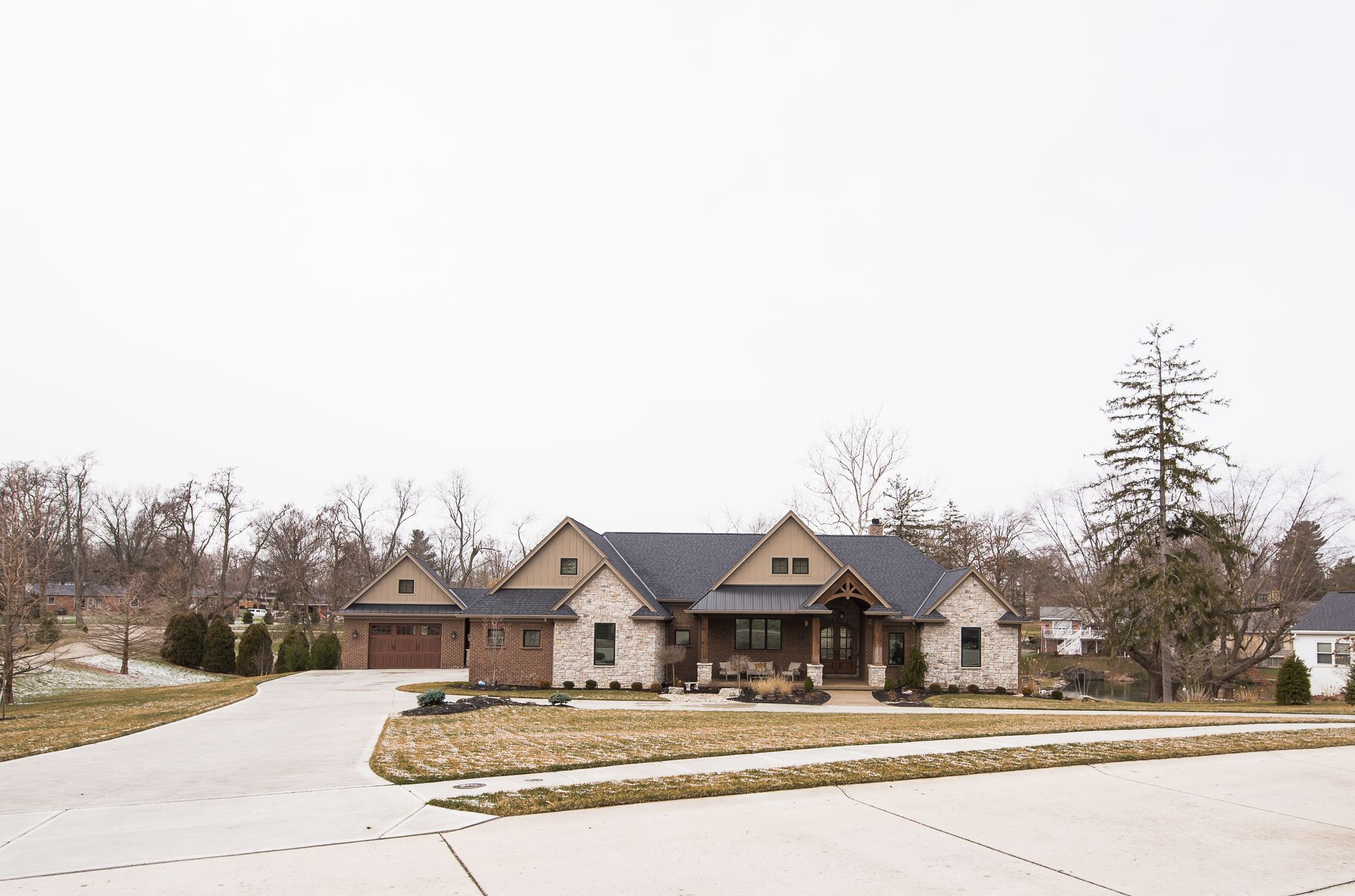 A large house is sitting on top of a lush green hillside.