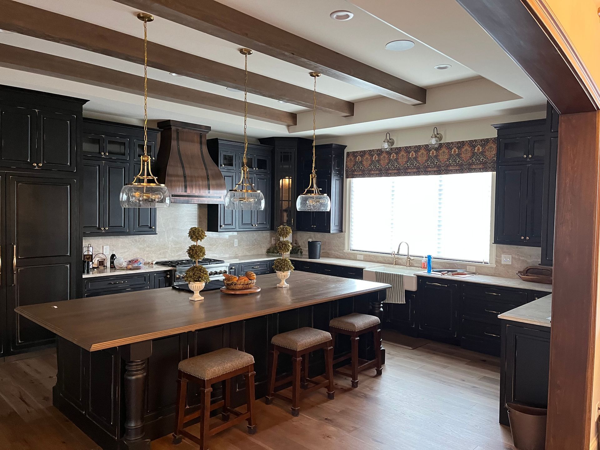 A kitchen with black cabinets and a large island