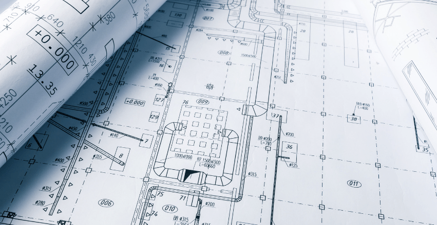 A blueprint of a building is rolled up on a table.