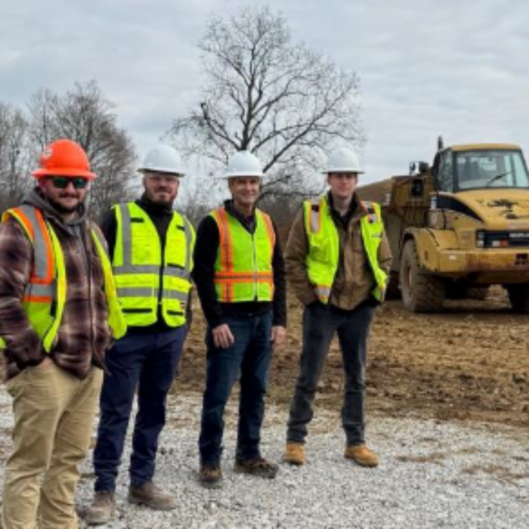 A group of Reston Contractor standing in front of a bulldozer