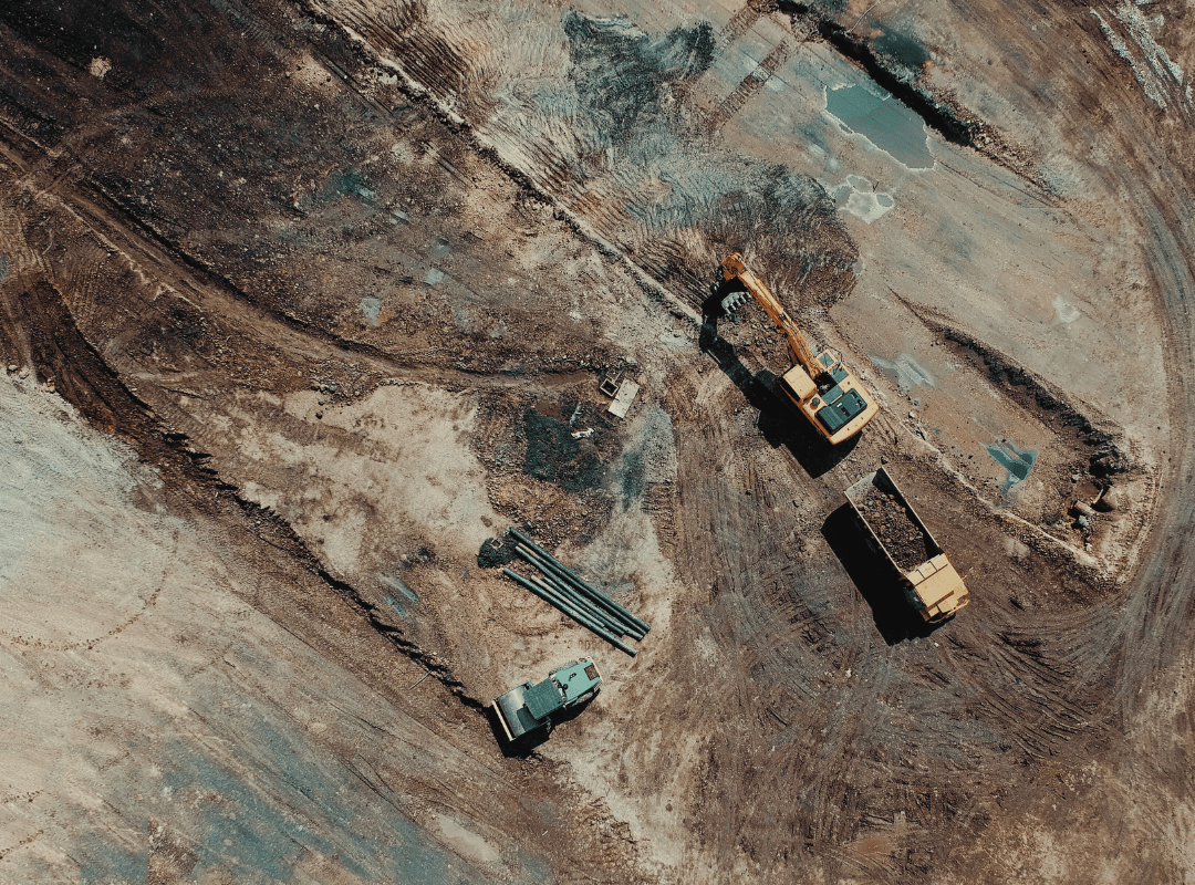 An aerial view of a construction site with trucks and bulldozers.
