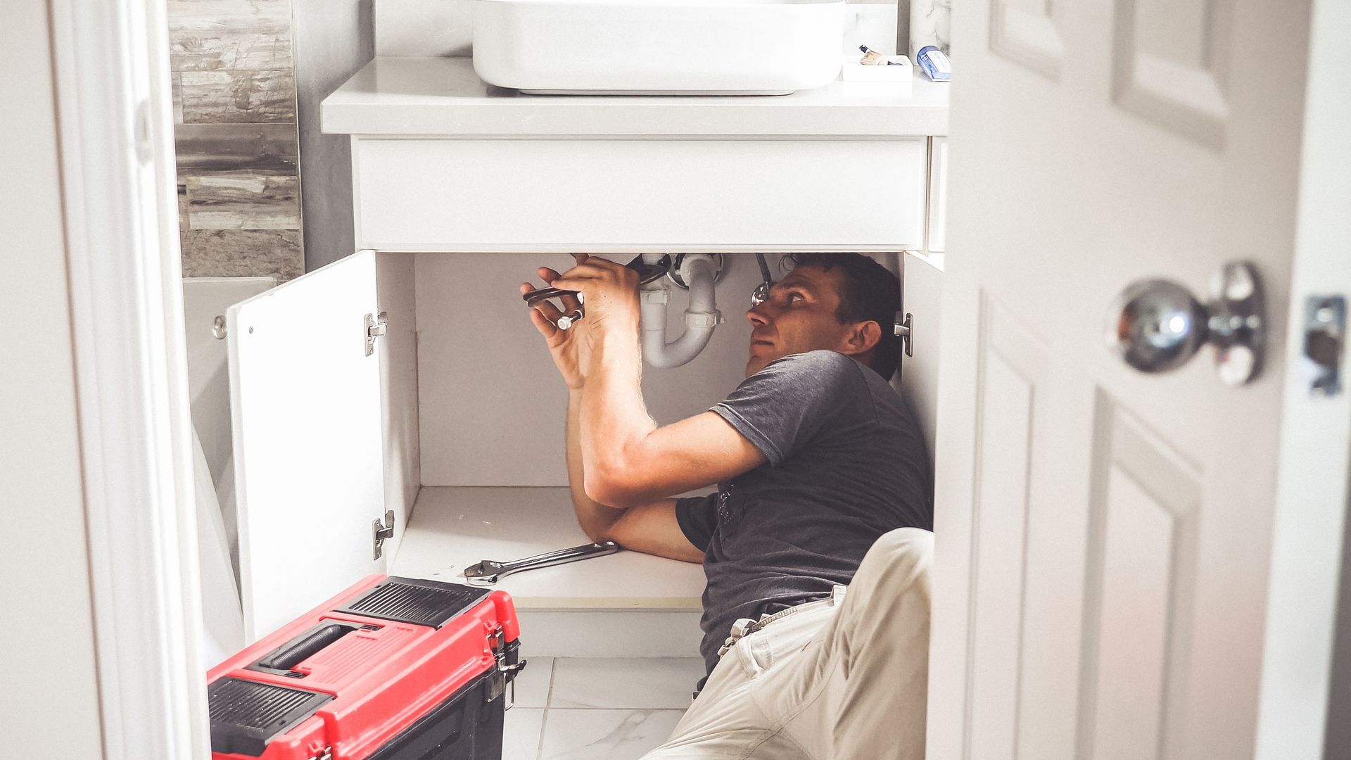 A Reston Contractor is fixing a sink in a bathroom.