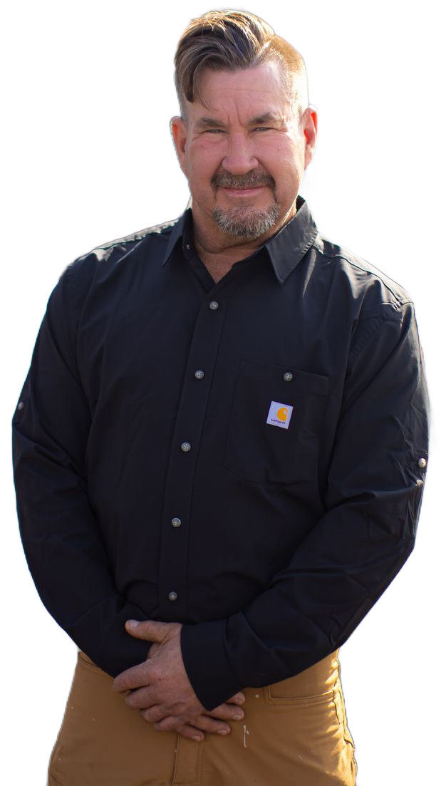 Man in black shirt, tan pants, smiling, hands clasped. Carhartt logo visible.