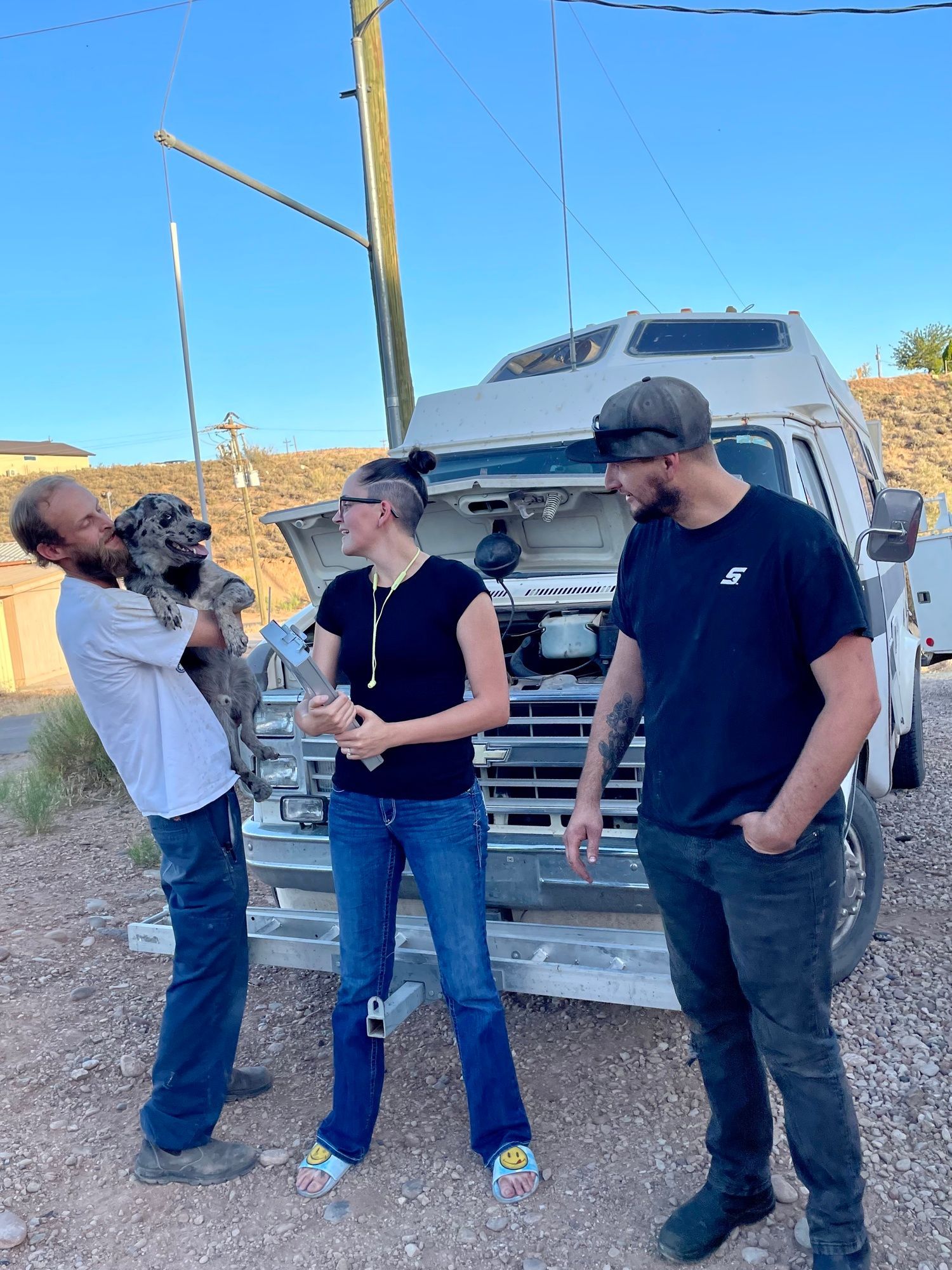 A group of people are standing in front of a truck.