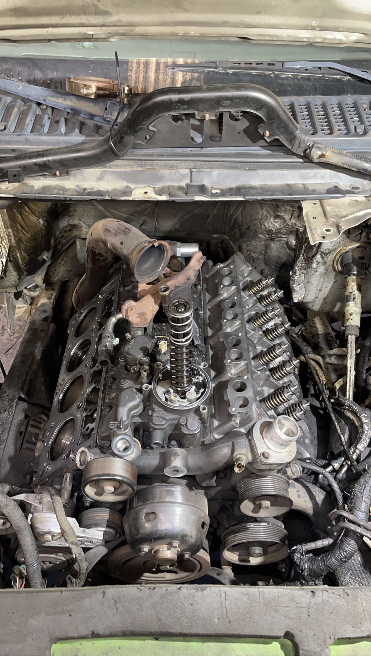 A close up of a car engine with the hood open.