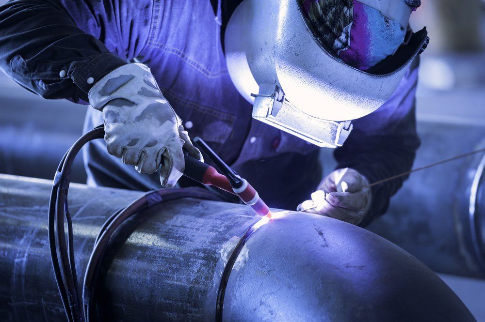 A Welder Meticulously Fuses Metal Pipes Together — AWE Engineering in South Lismore, NSW