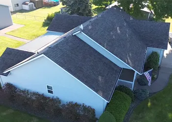 The roof of a building with a white roof and trees in the background.