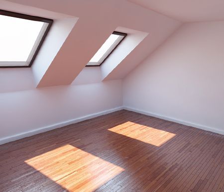 An empty room with two skylights on the ceiling