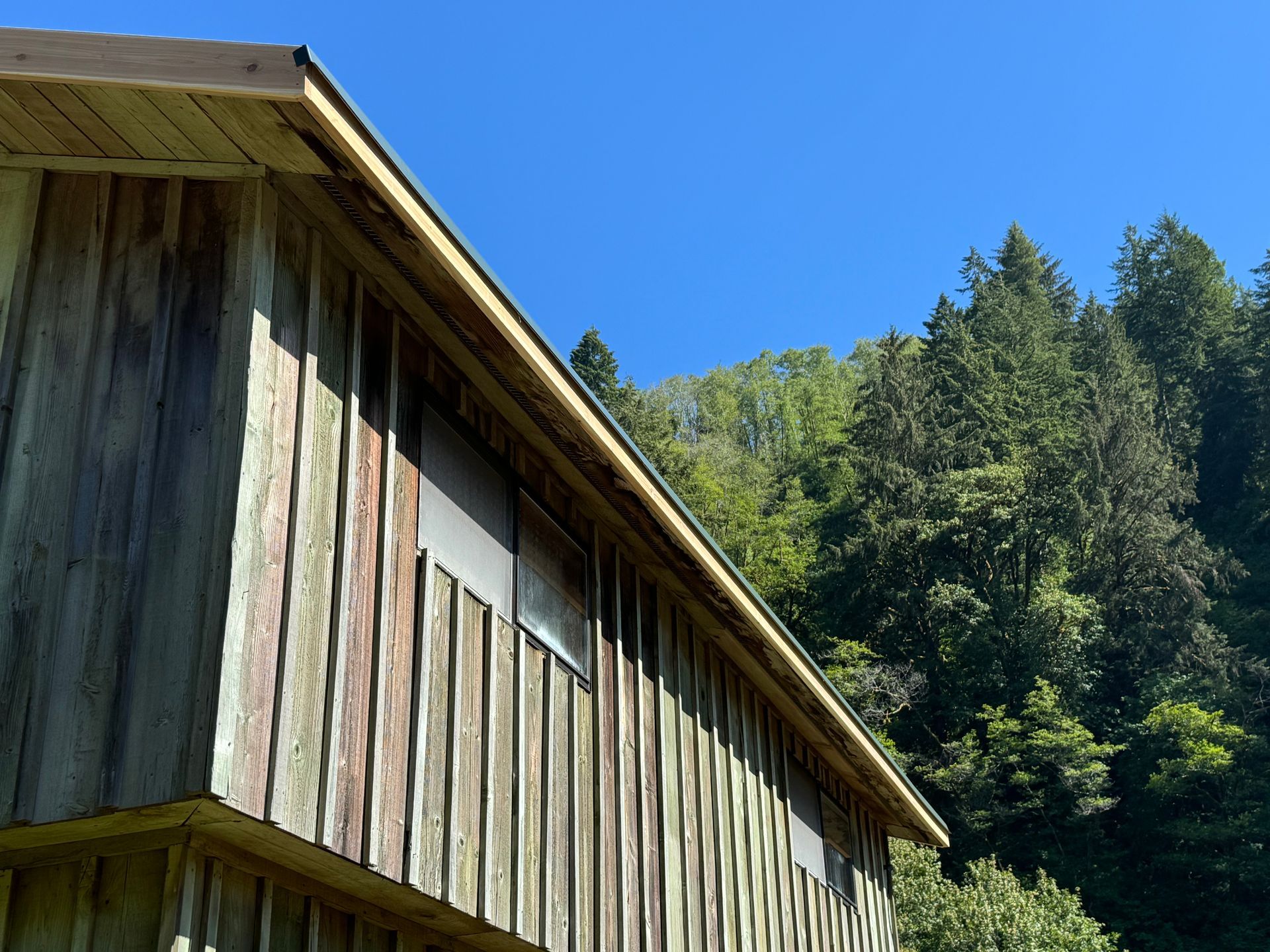 A wooden building with trees in the background and a blue sky