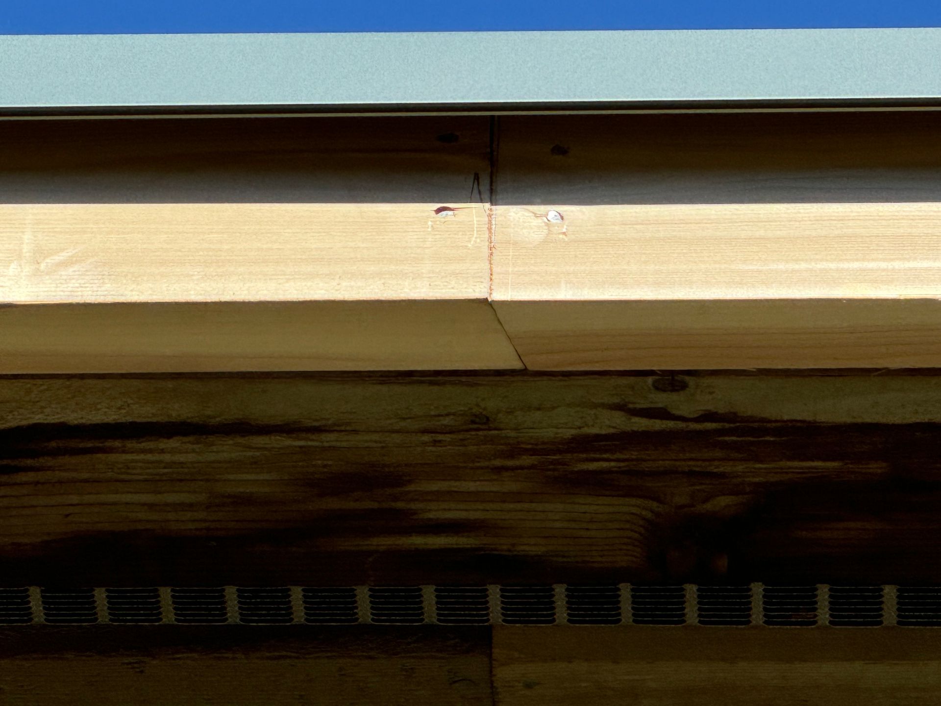 A close up of a wooden roof with a metal gutter.