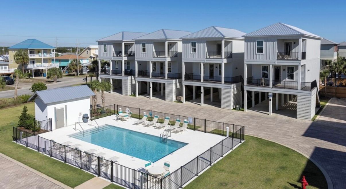 Seasonally heated pool, with patio furniture and outdoor restrooms at Rest Ashore in Gulf Shores, Alabama