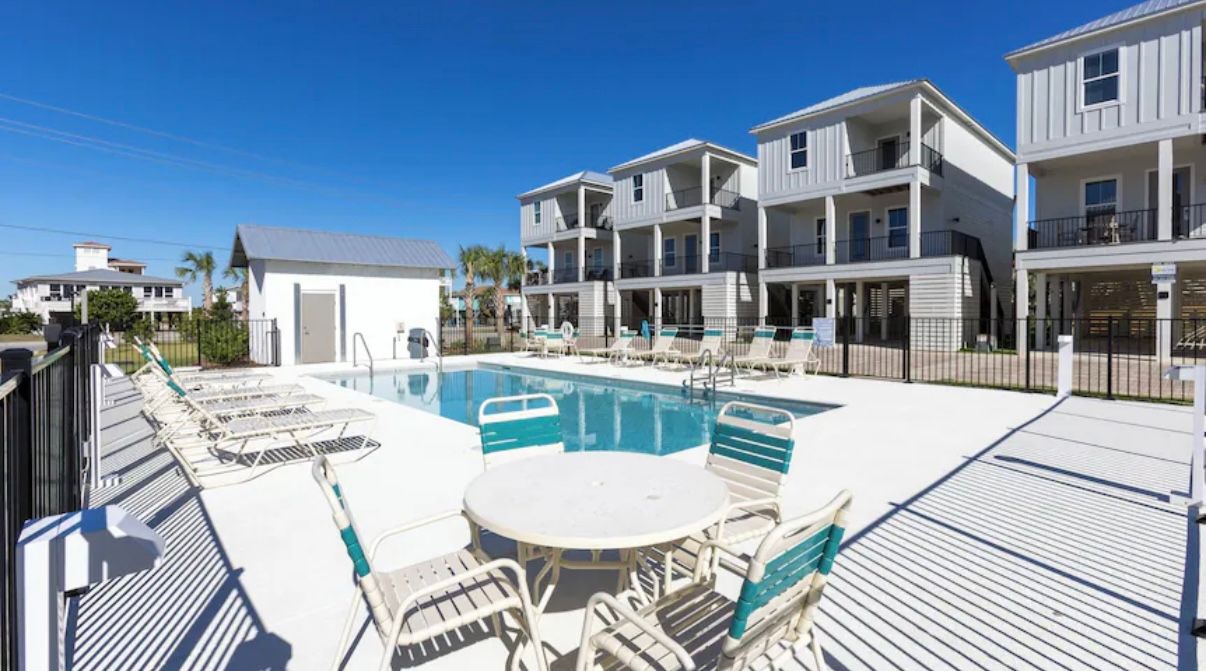 Seasonally heated pool with patio furniture and outdoor restrooms at Rest Ashore in Gulf Shores, Alabama