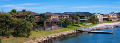 A row of houses next to a body of water with a dock.