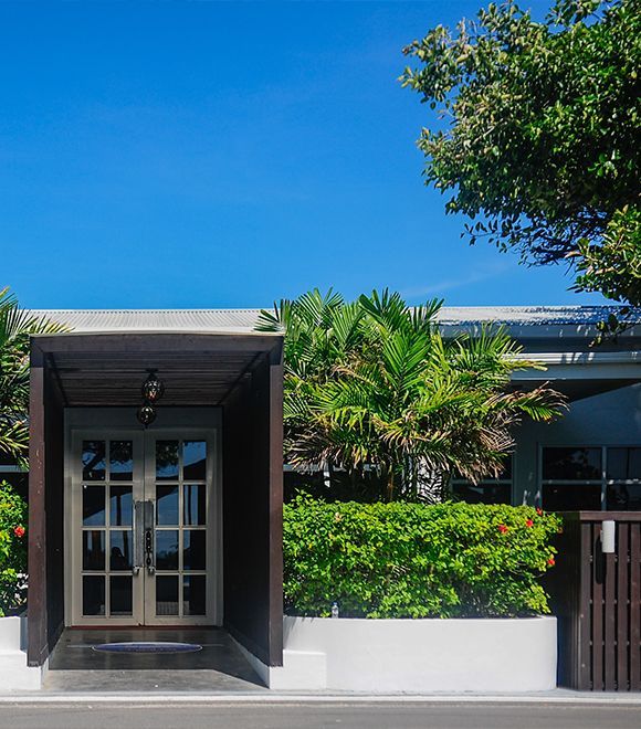 A house with a covered entrance and a blue sky in the background