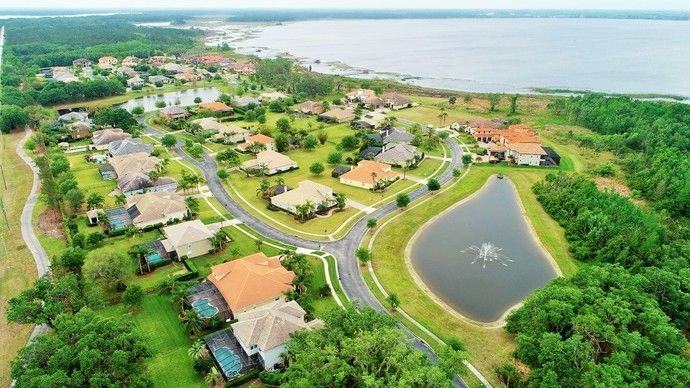 An aerial view of a residential neighborhood with a lake in the background.