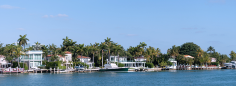 A row of houses on a small island in the middle of a body of water.