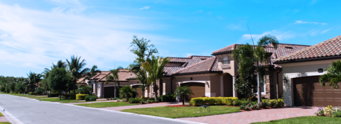 A row of houses are lined up on the side of a road.