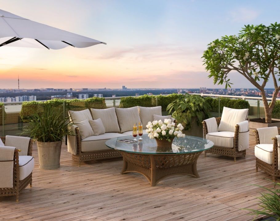 A wooden deck with a couch , chairs , a table and an umbrella.