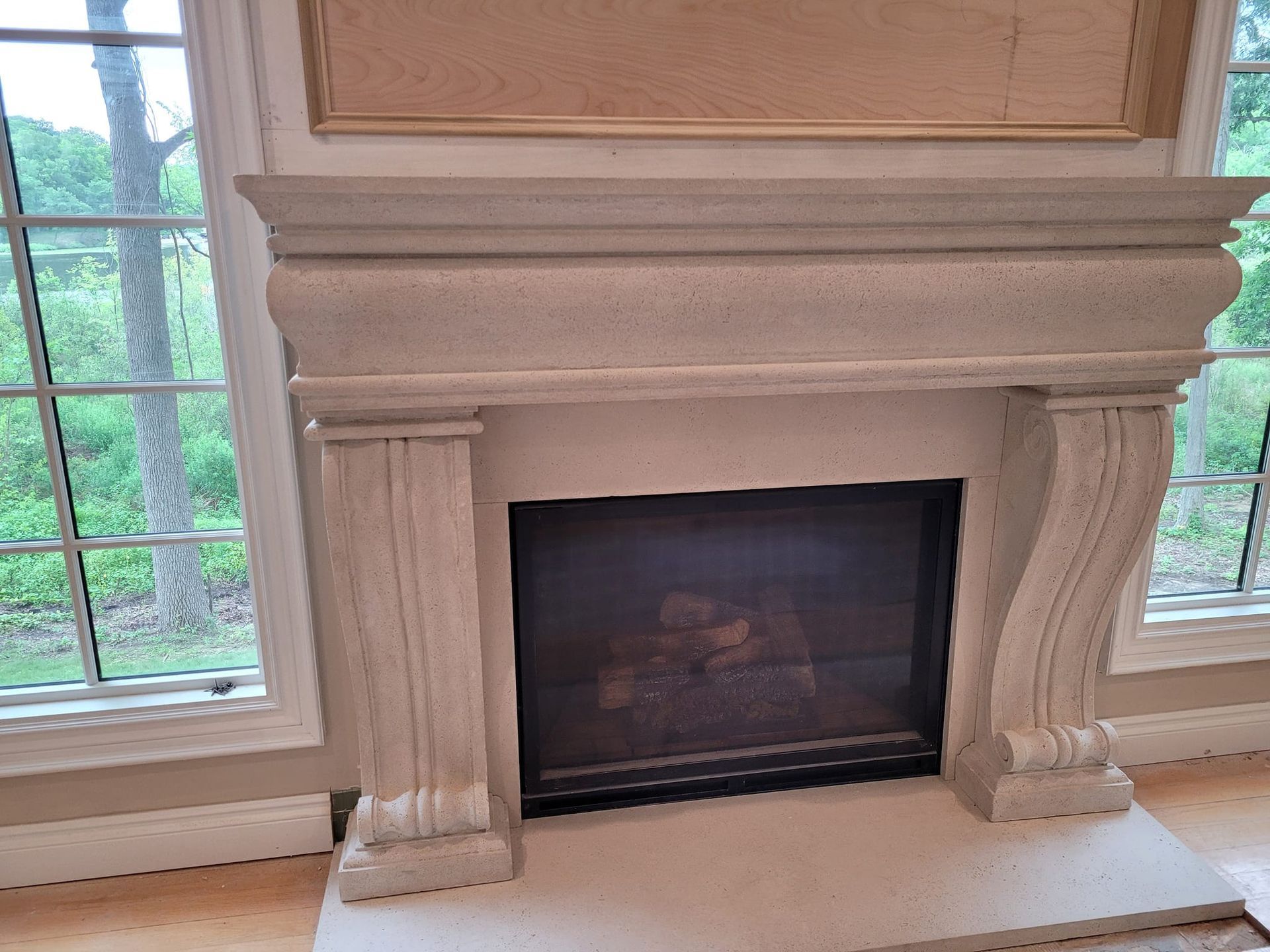 A fireplace with a mantle and a window in a living room.