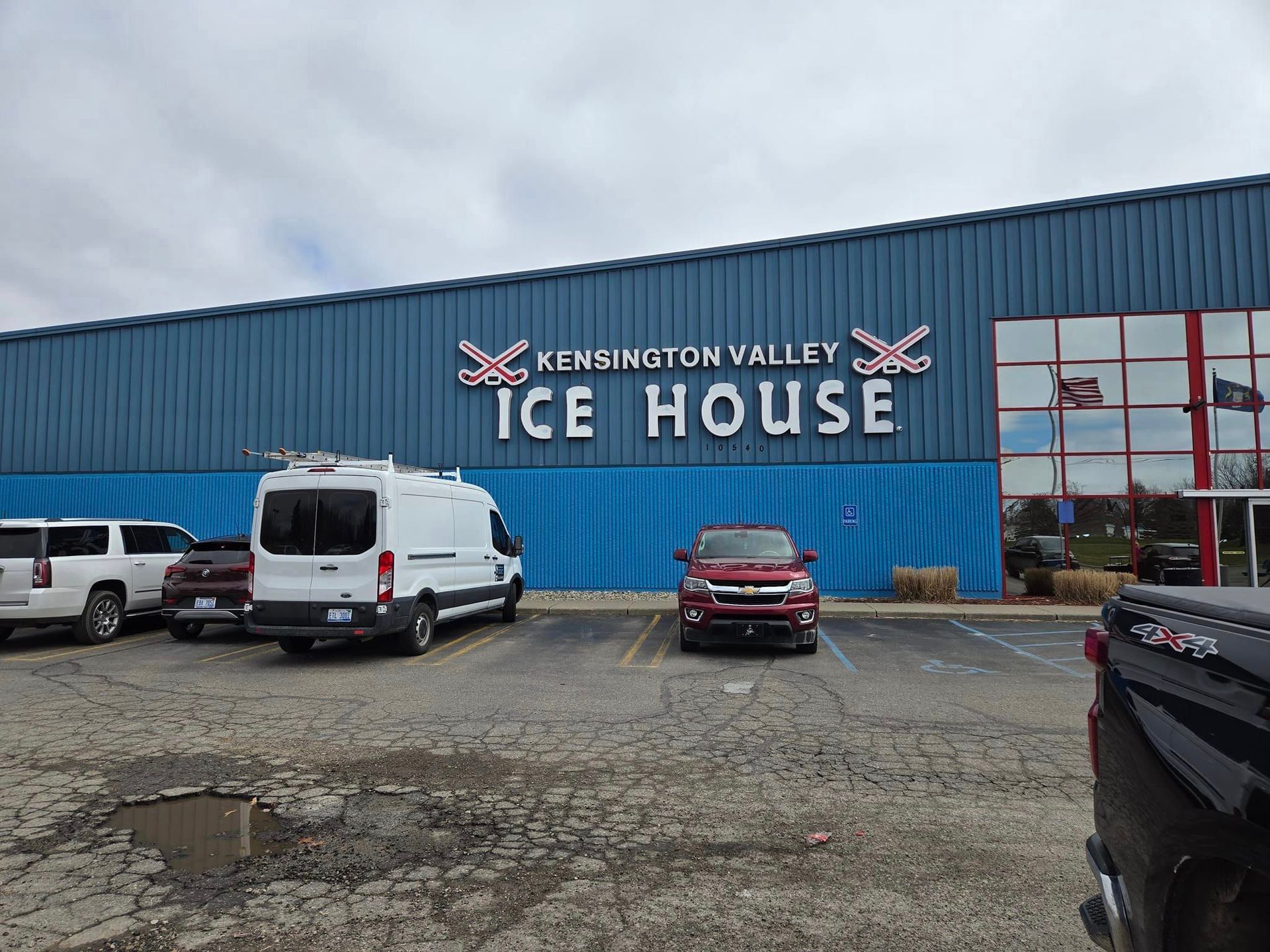 The ice house is a large building with a lot of cars parked in front of it.