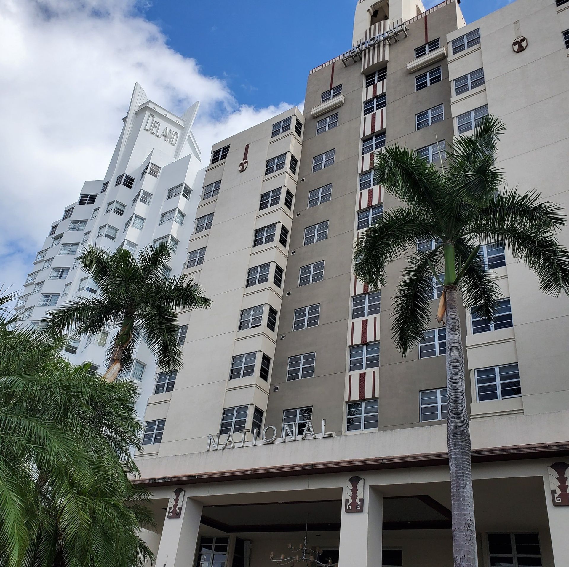 A tall building with a palm tree in front of it