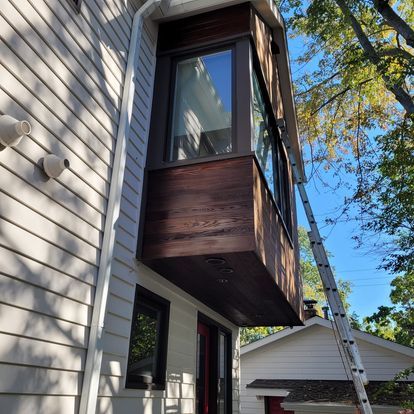 A ladder is hanging from the side of a house.