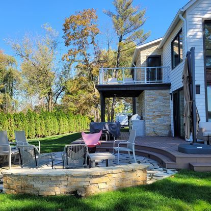 A house with a fire pit and chairs in front of it