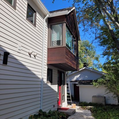 A white house with a balcony on the side of it