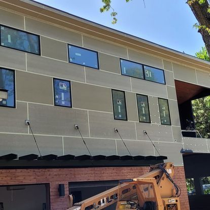 A large building with a lot of windows and a lift on the side of it.