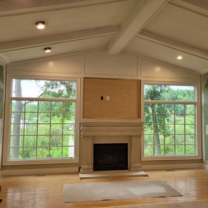 A living room with a fireplace and lots of windows