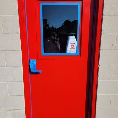 A red door with a blue trim and a window