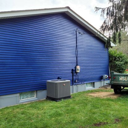A msu truck is parked in front of a blue house