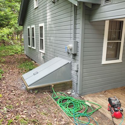 A house with a hose and an air compressor on the side of it.
