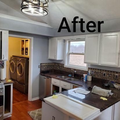 A kitchen with a sink , washer and dryer and a sign that says after