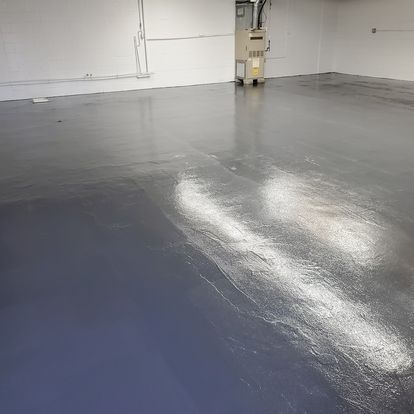 A large empty room with a blue floor and white walls.