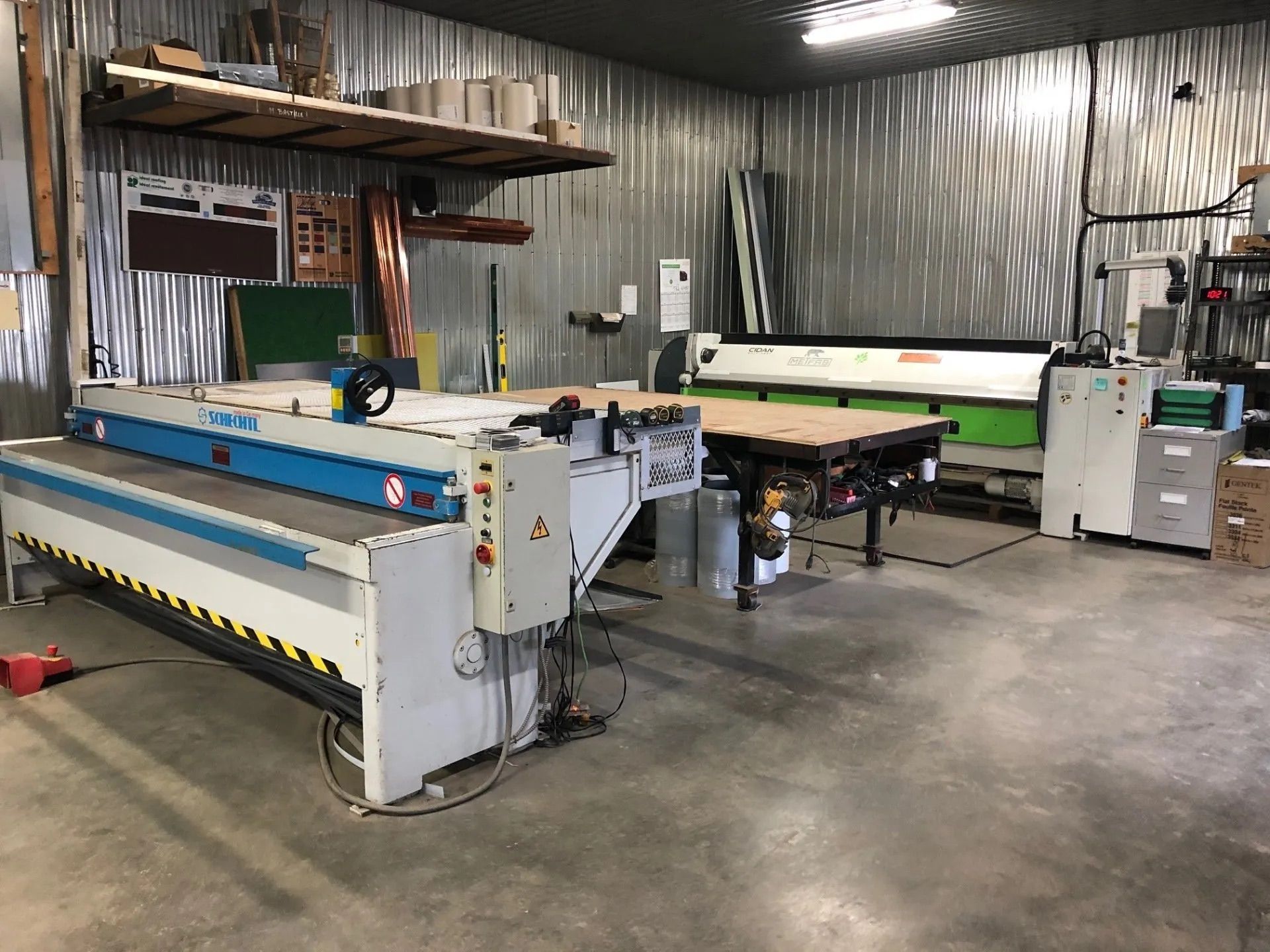 Workshop with large industrial machinery, metal walls, and a concrete floor.