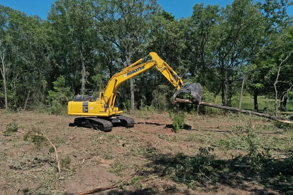 Backhoe attachment with a sturdy brush designed for heavy-duty cleaning and clearing debris.