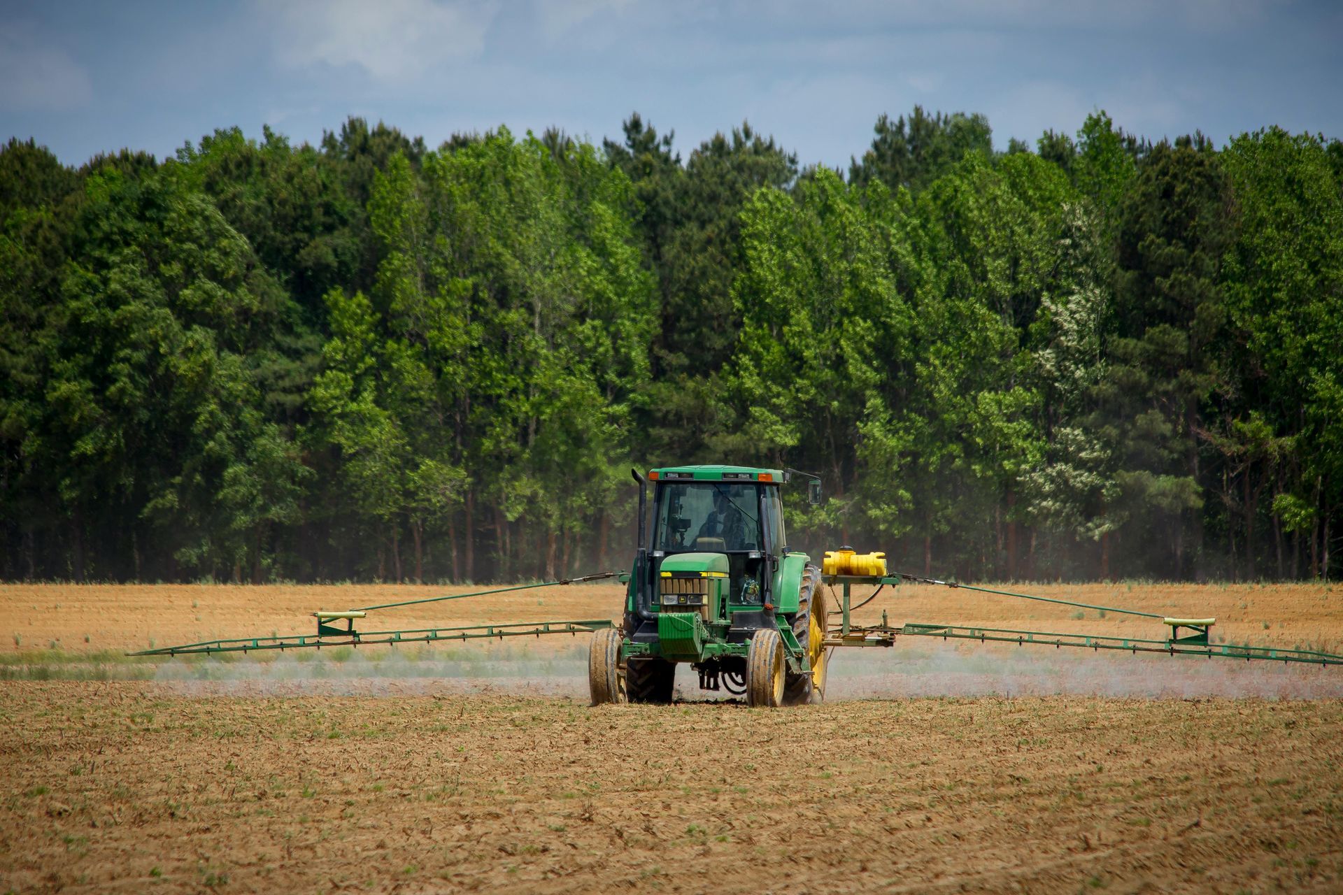 A green and yellow tractor on a field 